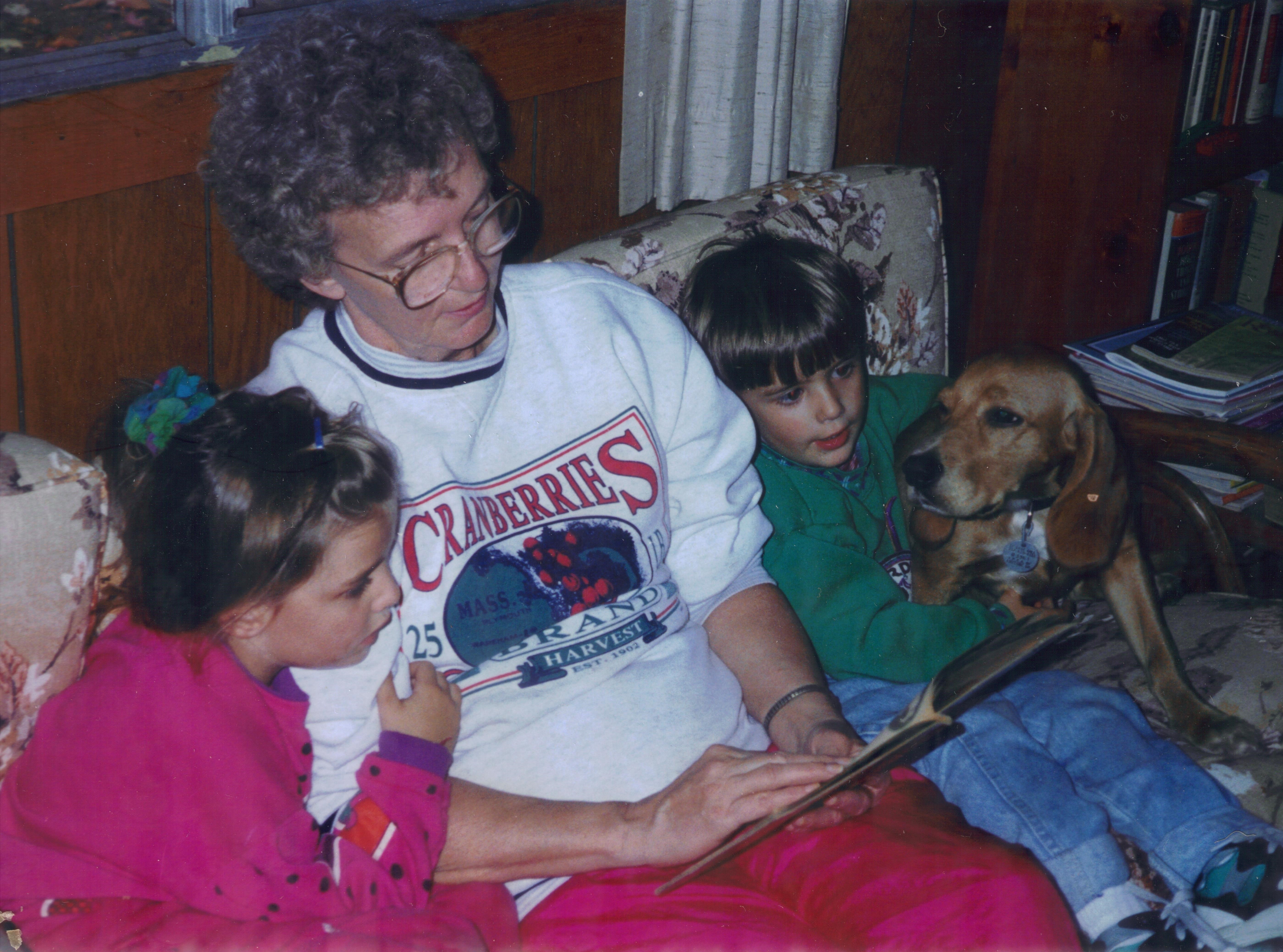 woman reading to girl, boy and dog